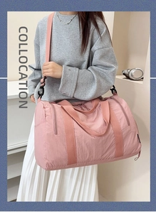 Pink nylon travel bag side view with adjustable shoulder strap and zipper pocket detail