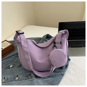 Detail view of light purple nylon crescent bag with mini coin purse on denim jacket
