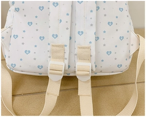 Detailed back view of canvas backpack straps with heart pattern and star prints