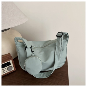 Close-up of mint green nylon crossbody bag with grid texture and mini round coin purse