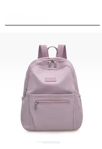 Detail view of a light purple nylon backpack featuring multiple pockets and durable zippers