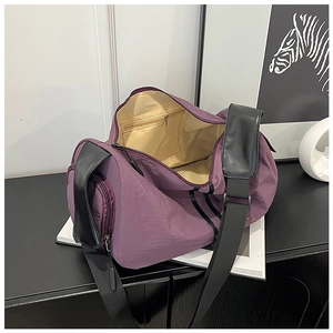 Detail view of purple travel bag showing brown lining and functional side pocket