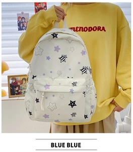 Close-up of lightweight white canvas backpack with purple star prints and front pocket