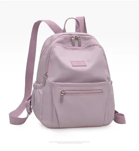 Detail of light purple nylon backpack with multiple zipper pockets and smooth texture