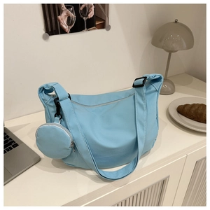 Detail view of light blue nylon crescent bag with adjustable strap and small round coin purse