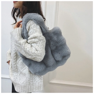 Détail de ce sac fourre-tout en peluche grise avec bords ondulés et texture douce
