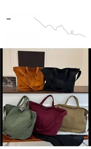 Multiple colors of large canvas tote bags stacked, showcasing versatile straps and style