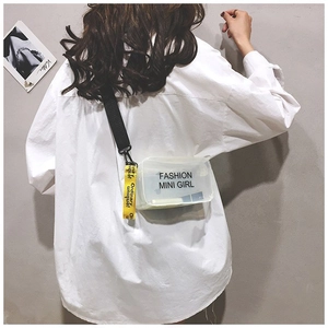 Detail view of transparent mini jelly bag with black strap and yellow slogan tag