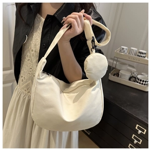 Detail of minimalist beige nylon crescent shoulder bag with matching round coin purse