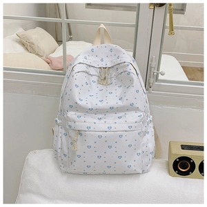 Detail of backpack fabric showing blue heart star patterns and durable cotton rope zippers