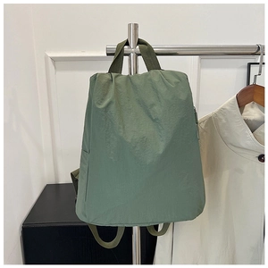 Detail view of the side zipper pocket on a green nylon backpack for travel