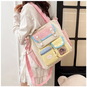 Detail of color-block canvas crossbody bag featuring functional multi-pockets and pink strap