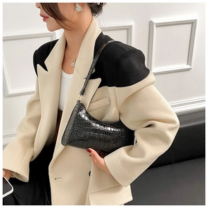 Detailed view of black crocodile pattern baguette bag with a stylish crescent shape and strap