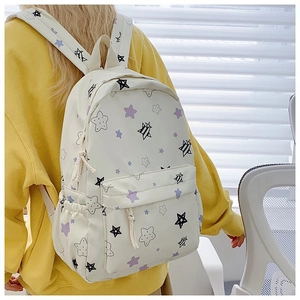 Detail of white backpack with purple star patterns showing side pockets and zipper