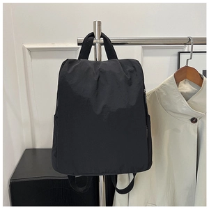 Detail view of durable black nylon backpack with padded handle and side pockets for travel