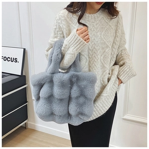 Gros plan détaillé du sac cabas en fausse fourrure grise avec texture patchwork en peluche