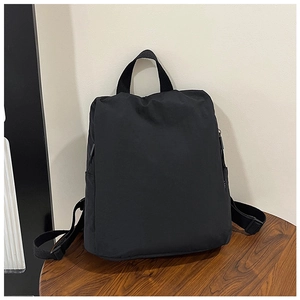 Detail view of durable black nylon backpack with reinforced top handle and adjustable straps
