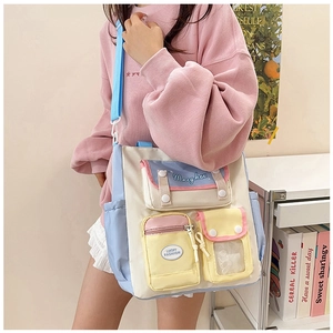 Detail view of multi-pocket canvas crossbody bag with color block design and embroidery