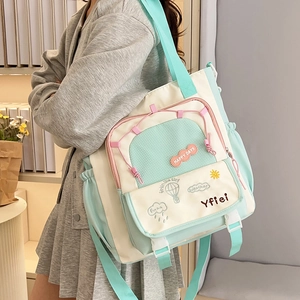 Detail of mint green and beige tote bag with Happy Days embroidery and shoulder strap