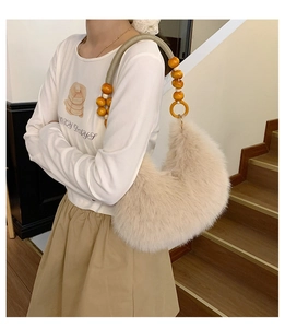 Détail de la poignée perlée et de la matière pelucheuse de ce sac croissant beige