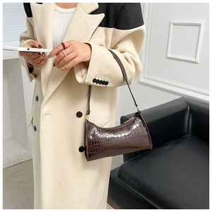 Close-up of brown crocodile pattern shoulder bag with golden buckle and zipper detail