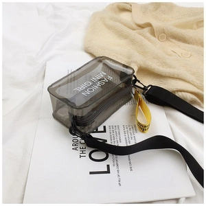 Detail view of mini transparent grey PVC jelly saddle bag with yellow strap charm