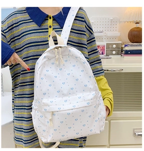 Detail view of a white waterproof backpack with blue heart and star prints for daily use