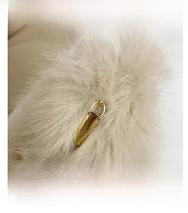 Gros plan du tissu pelucheux doux et du fermoir en métal doré sur le sac à main