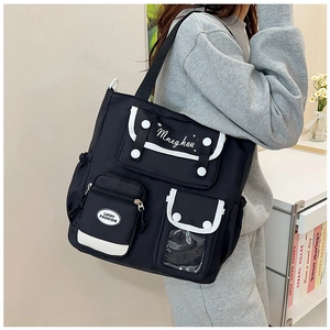 Detail view of multi-pocket nylon tote bag with white trim and functional zip pockets