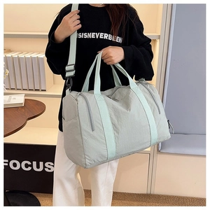 Detail of mint green large nylon gym bag with reinforced handles and adjustable shoulder strap