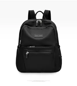Detailed front view of black nylon backpack featuring waterproof fabric and metal zippers