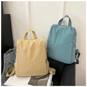 Minimalist nylon backpacks in beige and blue showing side zipper and handle details