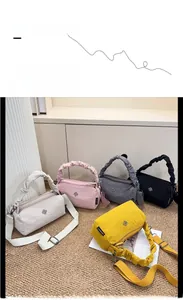 Detail showing multiple colorful nylon barrel bags with clover logo and ruched handles