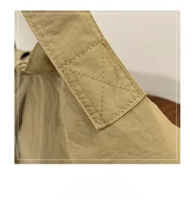 Close-up of reinforced cross-stitching on the khaki canvas tote bag shoulder strap