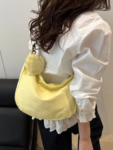 Minimalist light yellow nylon crossbody bag with mini pouch shown on model