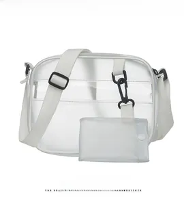 Close-up of clear PVC crossbody bag with white fabric strap and plastic buckle detail