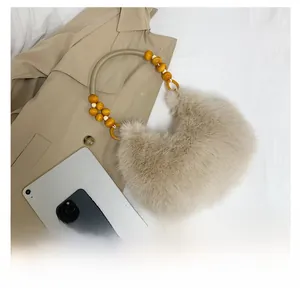Détail du sac croissant en peluche avec bandoulière perlée et fourrure douce