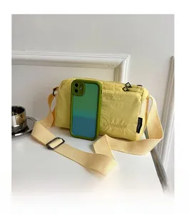 Size comparison of light yellow nylon shoulder bag with smartphone to show capacity