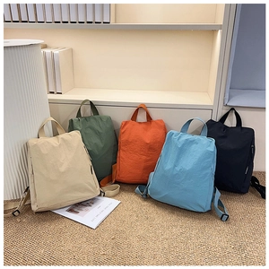 Minimalist nylon backpacks in beige, olive, orange, blue, and black shown in a lifestyle set