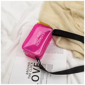 Detailed top view of a hot pink mini transparent jelly saddle bag on a magazine