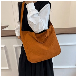 Detail of large burnt orange canvas tote bag with textured crinkle fabric and dual handles