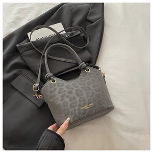 Detail of grey leopard print tote bag with gold ring hardware on stylish grey blazer