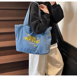 Vue détaillée du sac cabas en denim délavé avec broderie colorée au motif cœur rétro