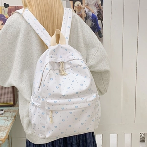 Lightweight white backpack with blue hearts and grey stars worn by a model in casual setting