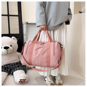 Pink nylon travel bag detail showing large capacity, durable webbing straps and smooth zippers