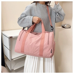 Detail view of pink waterproof nylon travel duffel bag with side zipper compartment