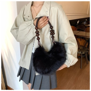 Gros plan du sac en fausse fourrure noire avec poignée en perles de bois marron foncé