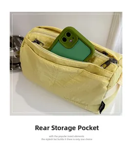 Detail of light yellow nylon bag showing the rear storage pocket with a smartphone inside