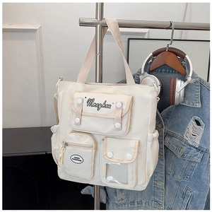 Detail of canvas tote bag showing functional multi-pockets and cream workwear style