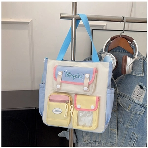 Detail of color-block canvas bag with multiple pockets and functional zippers